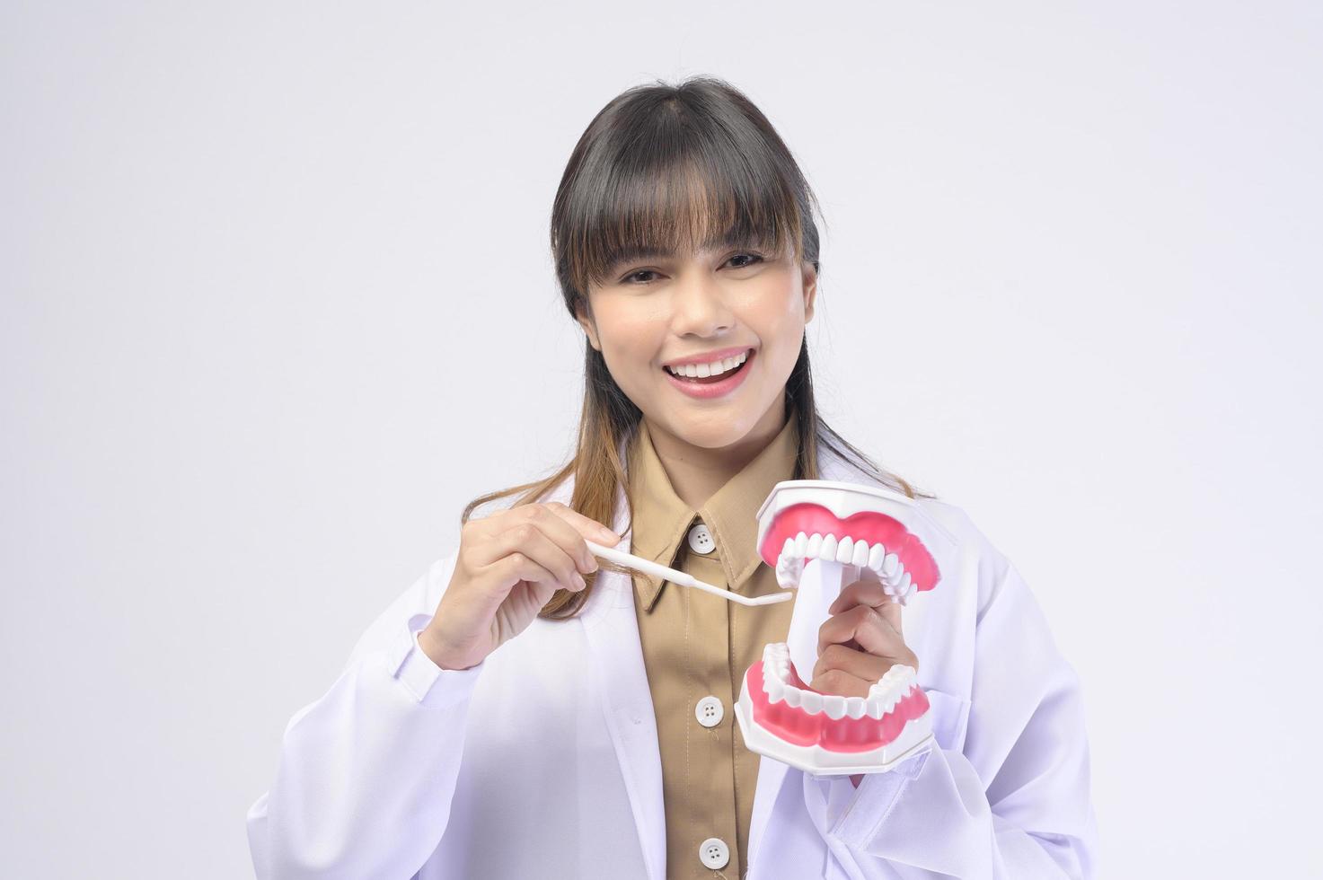 Young female dentist smiling over white background studio photo