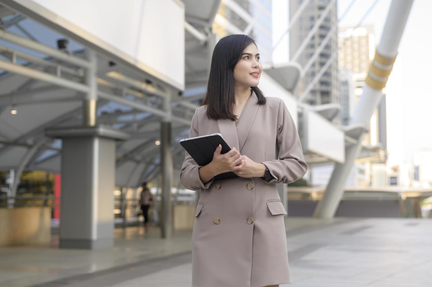 A young beautiful businesswoman is using tablet in Modern city , business technology , city lifestyle concept photo