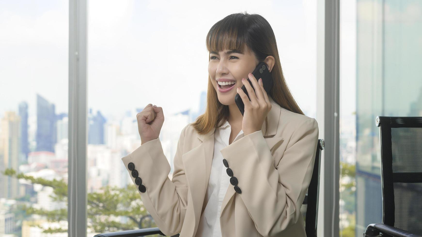 Young beautiful Business Woman using smart phone in modern office photo