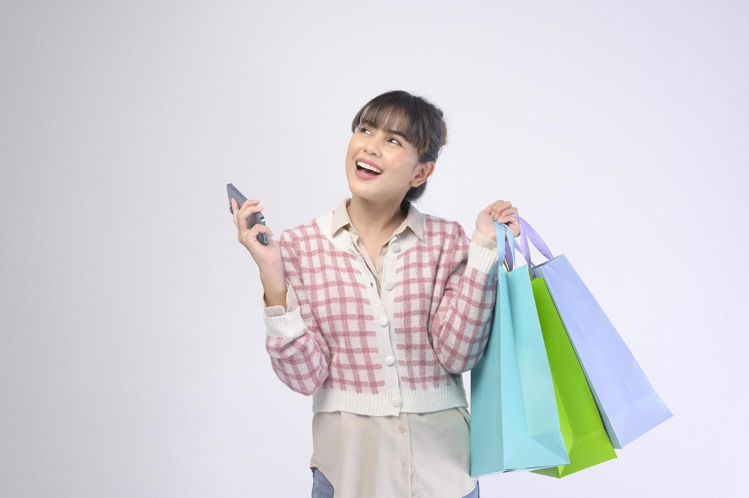Shopper atractiva mujer sosteniendo bolsas de compras sobre fondo blanco. foto
