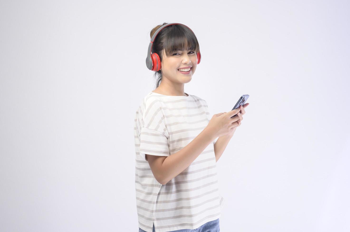 Hermosa mujer joven con auriculares sobre fondo blanco. foto