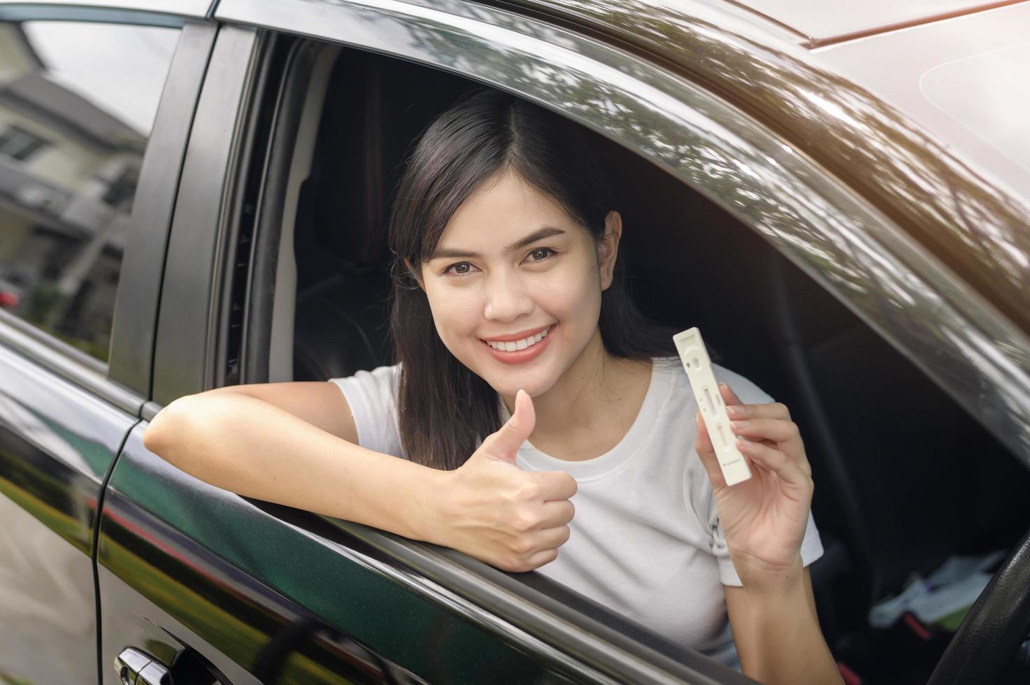 A woman holding atk in car, do a self-collection test for a COVID-19 test, health and safety photo