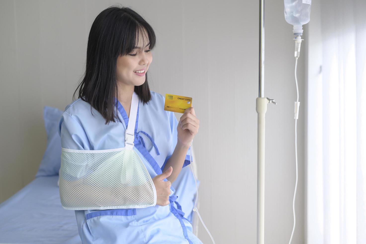 A young patient woman is holding credit card , admitting in hospital , Health care  concept photo