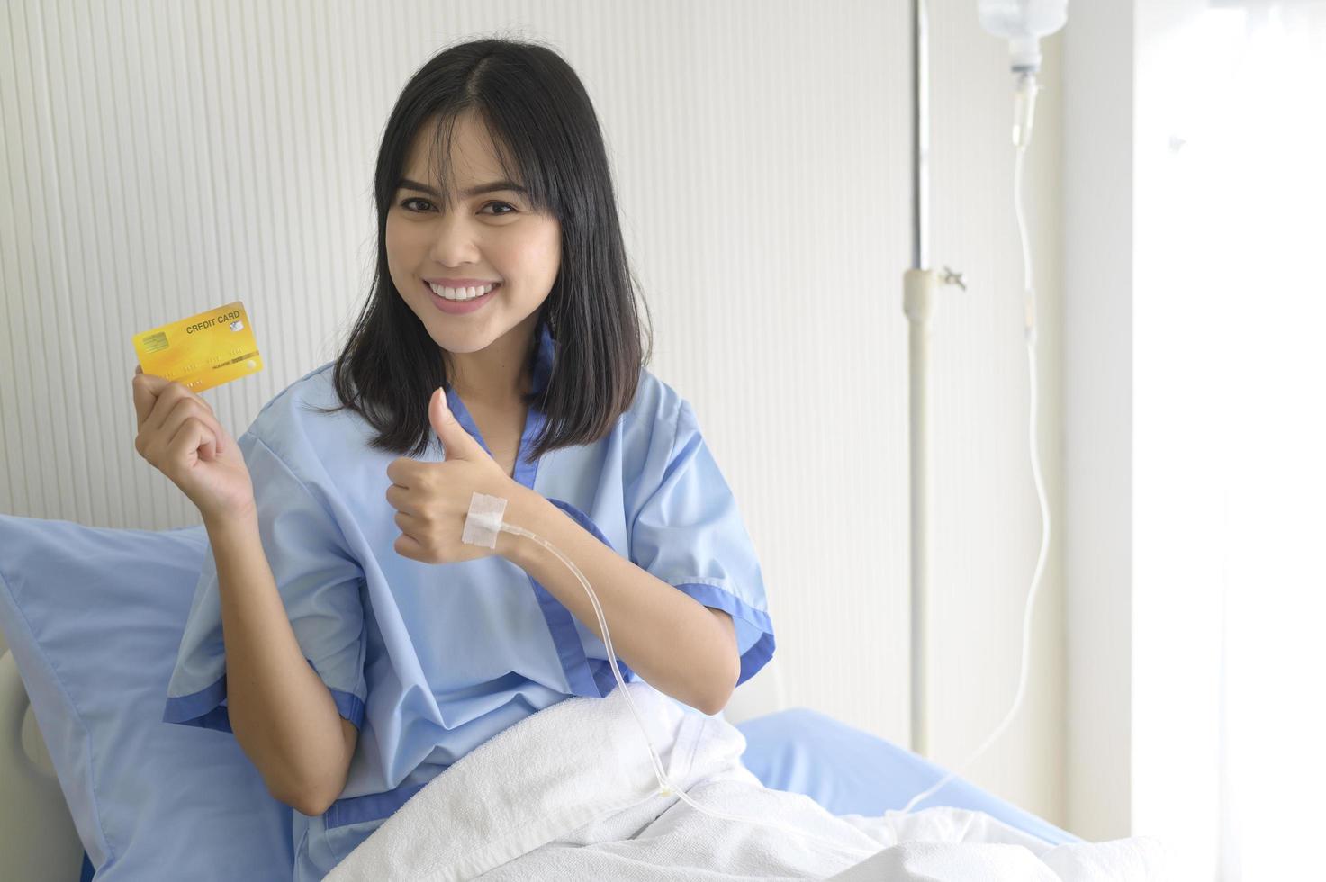 A young patient woman is holding credit card , admitting in hospital , Health care  concept photo