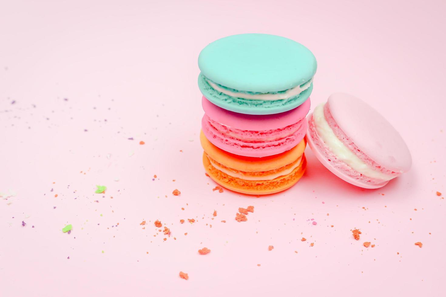 Colorful french macarons macaroons cake,  delicious sweet dessert on a pink background with copyspace, food background concept. photo