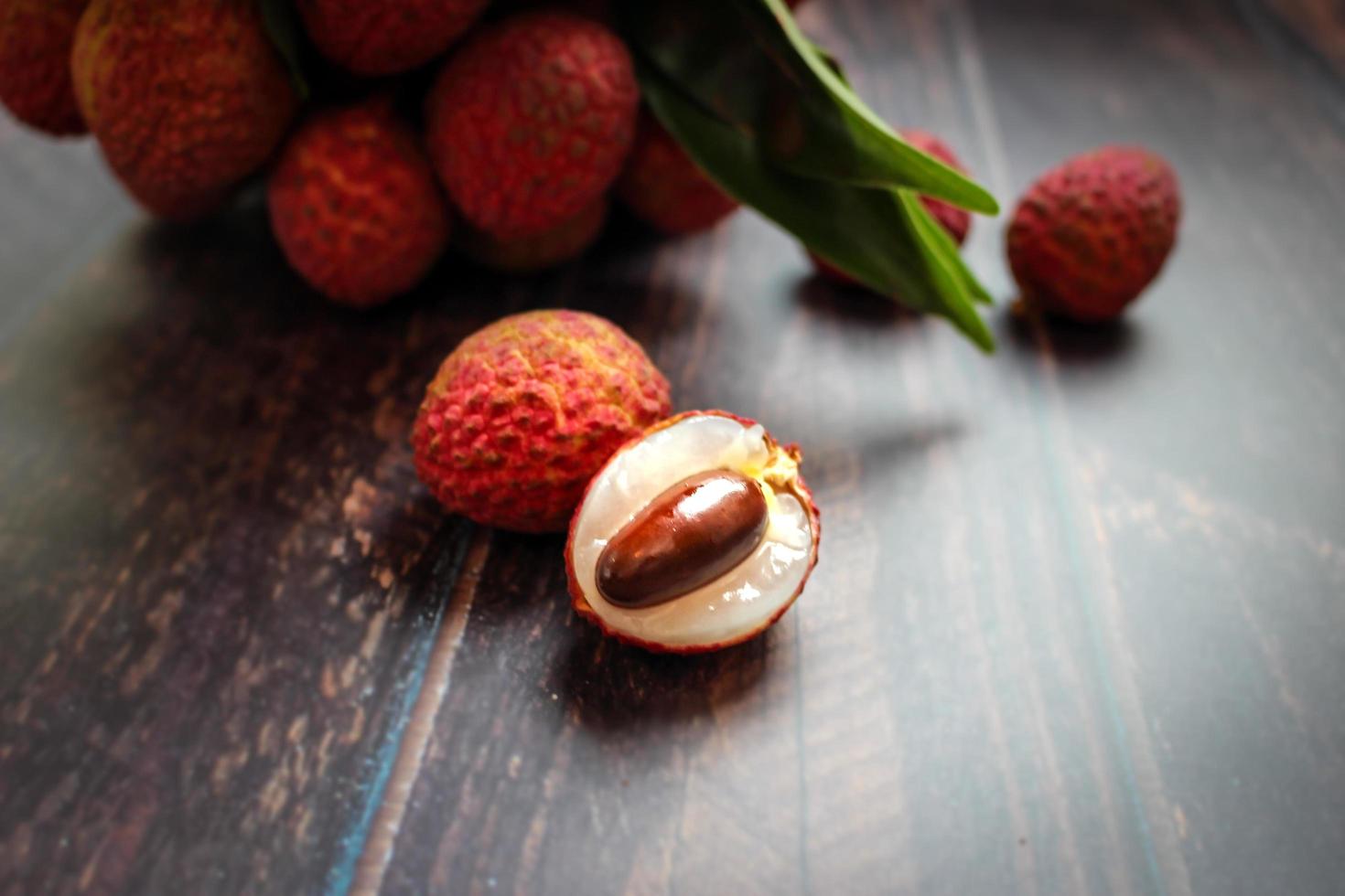 Fresh lychee fruits Litchi with leaves on wooden table photo