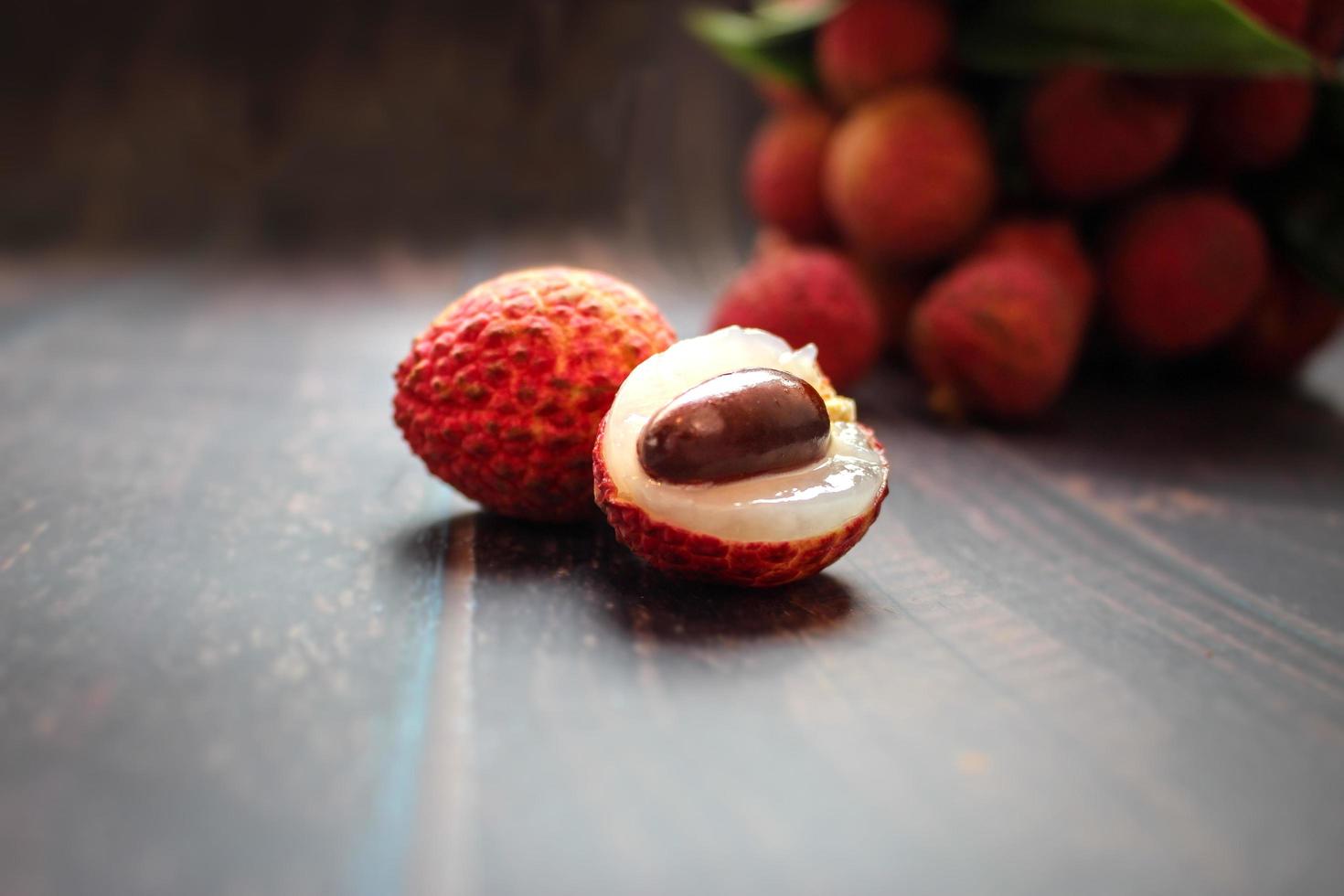Fresh lychee fruits Litchi with leaves on wooden table photo