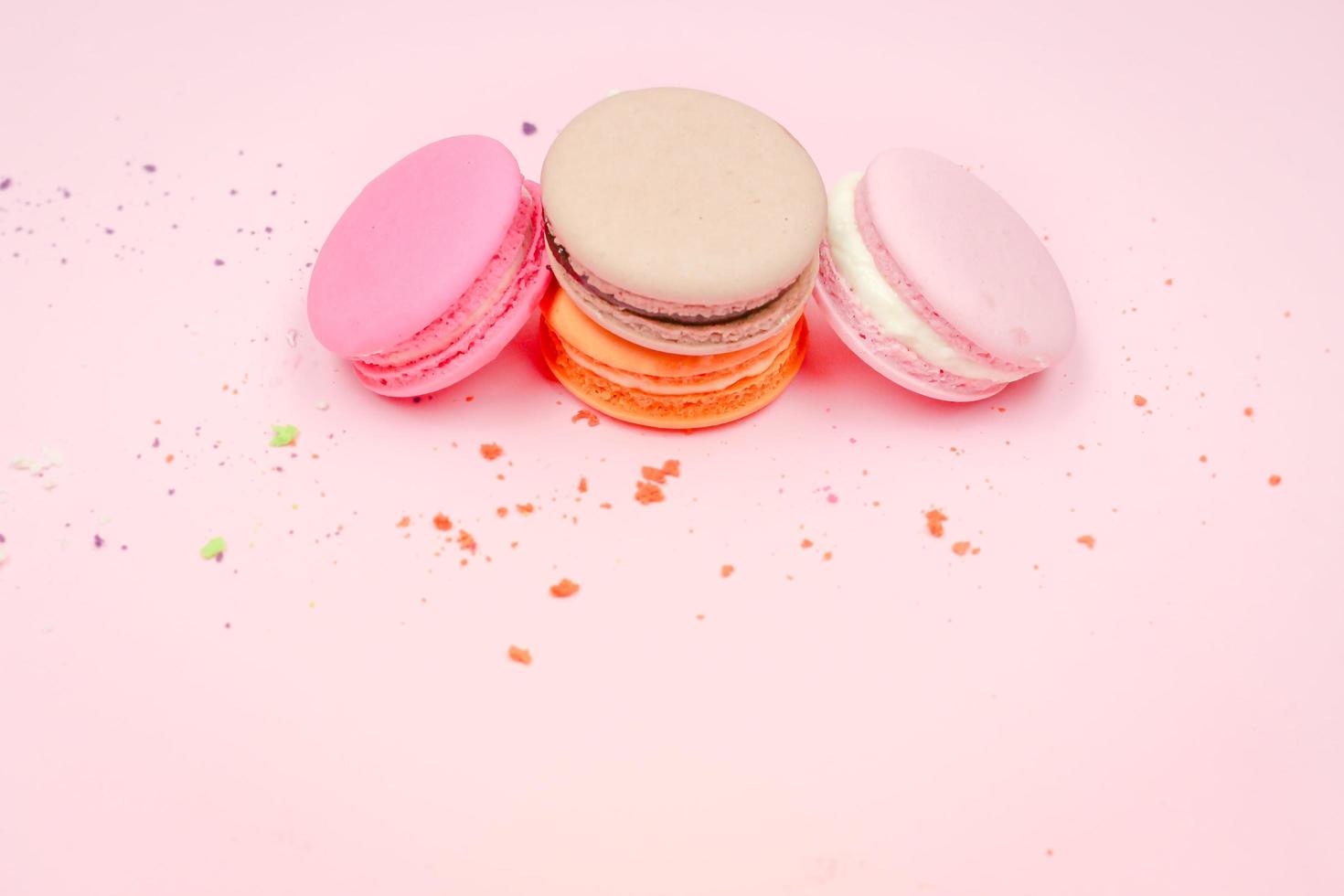 Colorful french macarons macaroons cake,  delicious sweet dessert on a pink background with copyspace, food background concept. photo