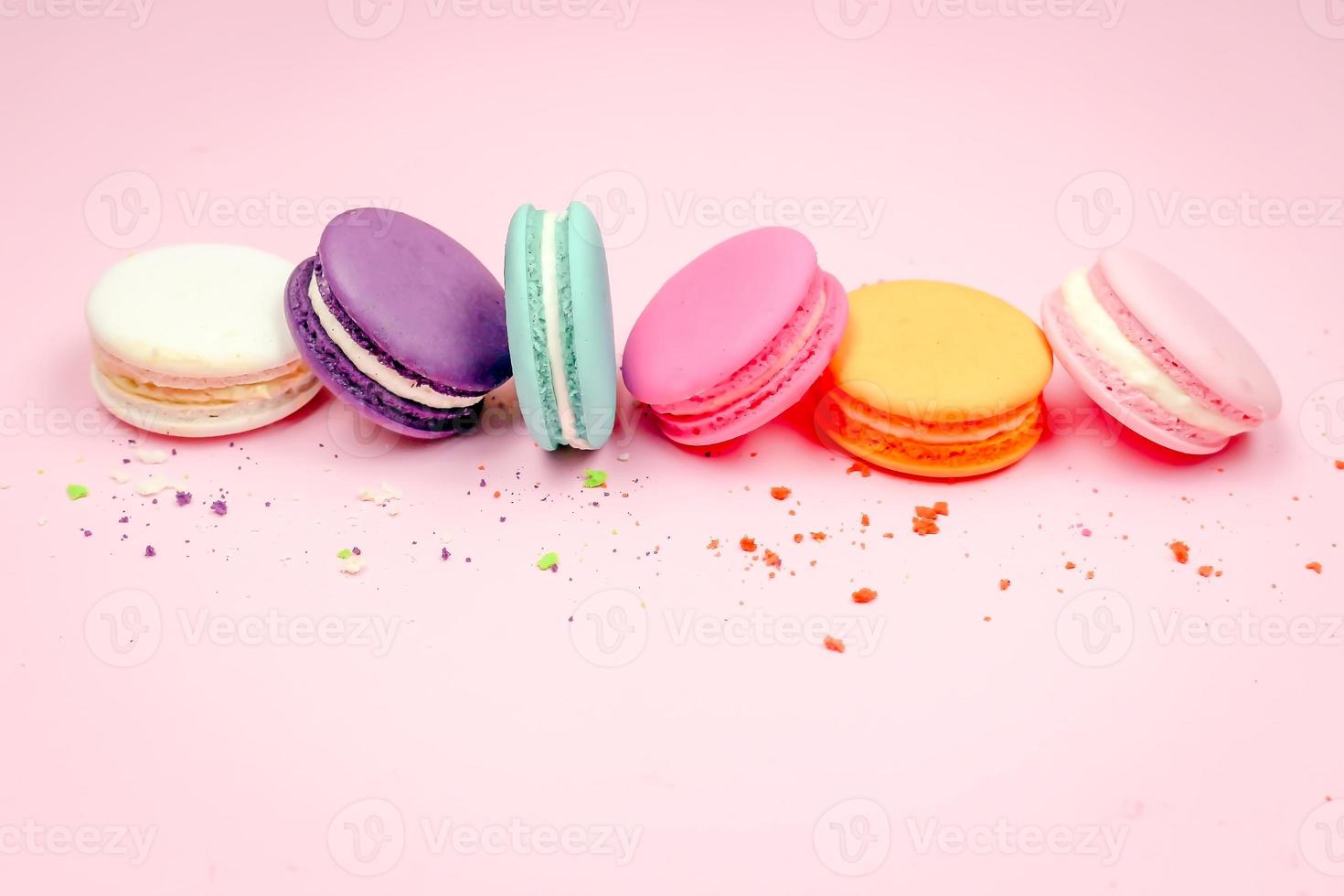 Colorful french macarons macaroons cake,  delicious sweet dessert on a pink background with copyspace, food background concept. photo