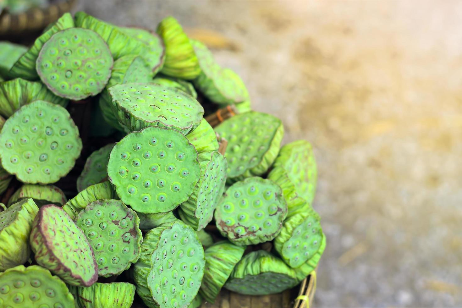 semilla de loto verde fresca con vaina en cesta de trilla de bambú a la venta en el mercado. foto