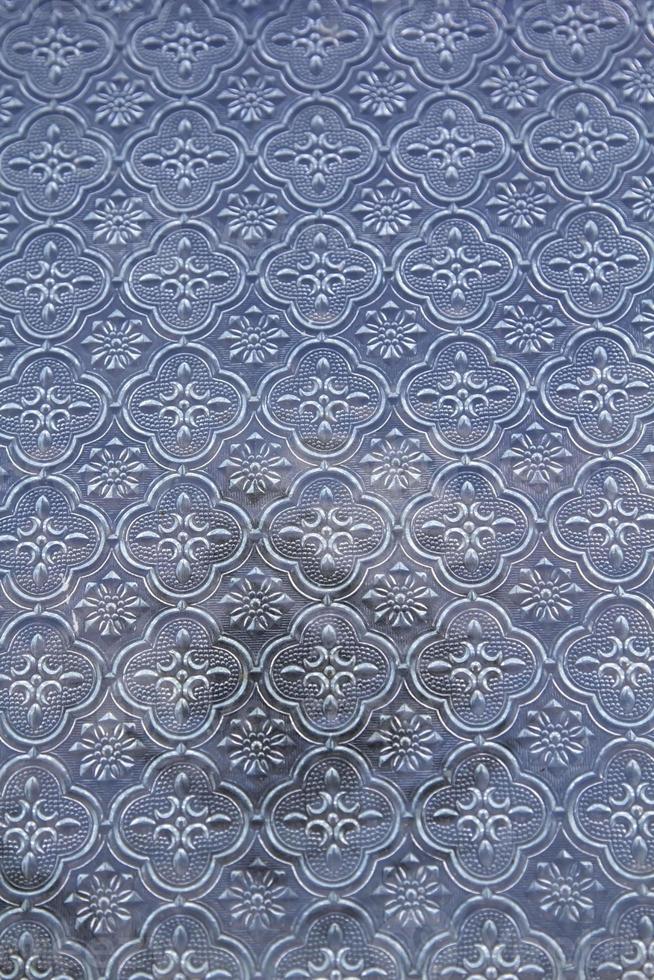 window glass of the old house with the floral pattern has the fine art pattern of the ancient artisan with the exquisite workmanship which is beautifully designed. photo