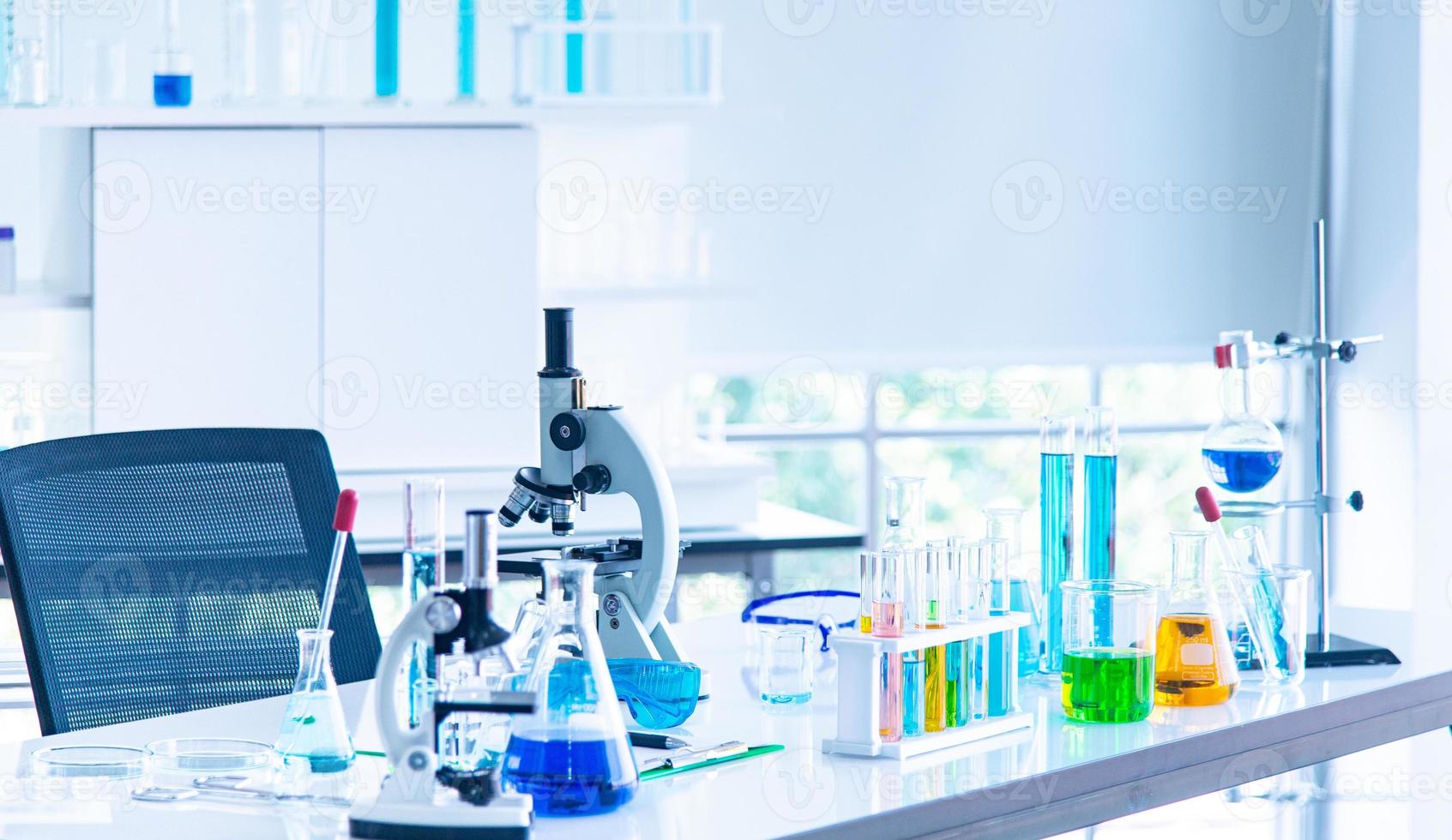 Preparing Laboratory equipments microscope glassware tube with blue liquid on the white table. The reseach experiment to discover the new virus vaccine in laboratory photo