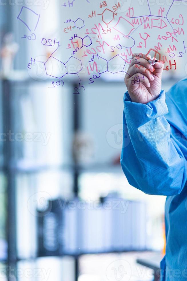 The scientists, chemists, researcher discover the chemical formula write on whiteboard in laboratory. The researcher discover vaccine or drug for treatment patients infected COVID19. photo