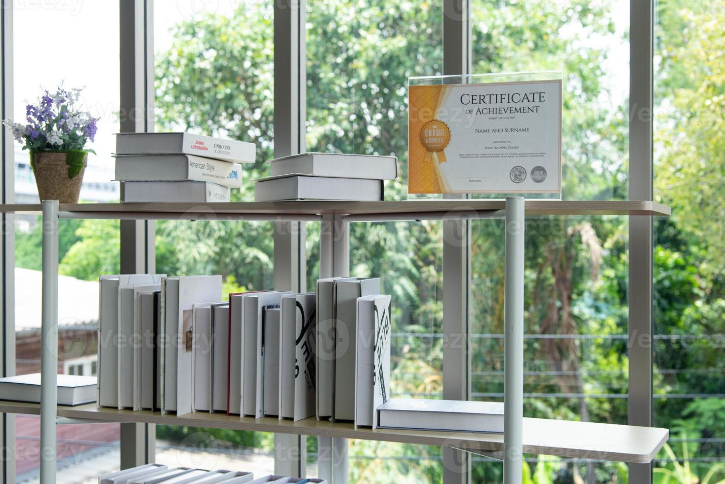 Certificate of achievement on the bookshelf in the modern library photo