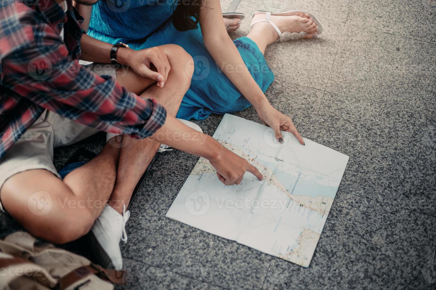 Close up. Young couple planning honeymoon vacation trip with map. Overhead view of Traveler's Young couple backpack planning. photo