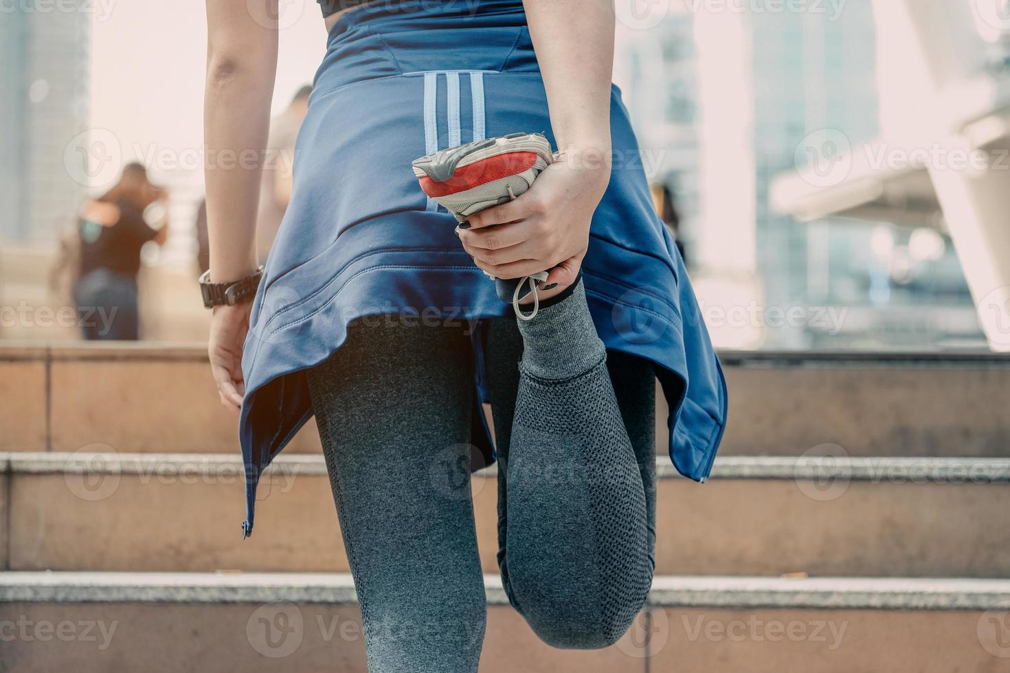 A men athlete doing warming stretching in the city street. Tight sport clothes. Urban workout. photo