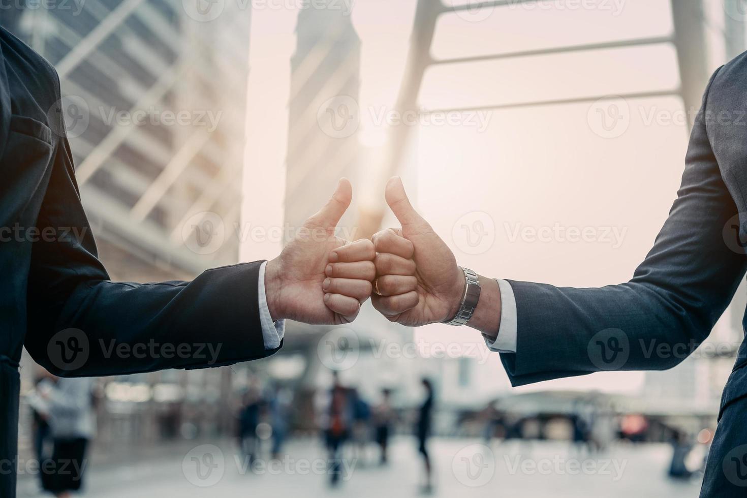 Businessman in suit handshake together for successful in city and walking people background. photo