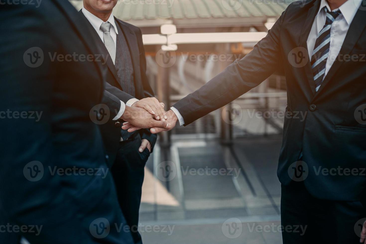 Businessman in suit handshake together for successful in city and walking people background. photo