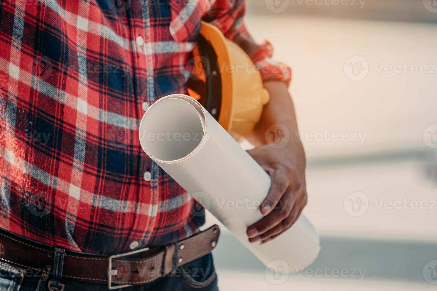 Close Up Engineering holding Safety helmet and a blueprint. photo