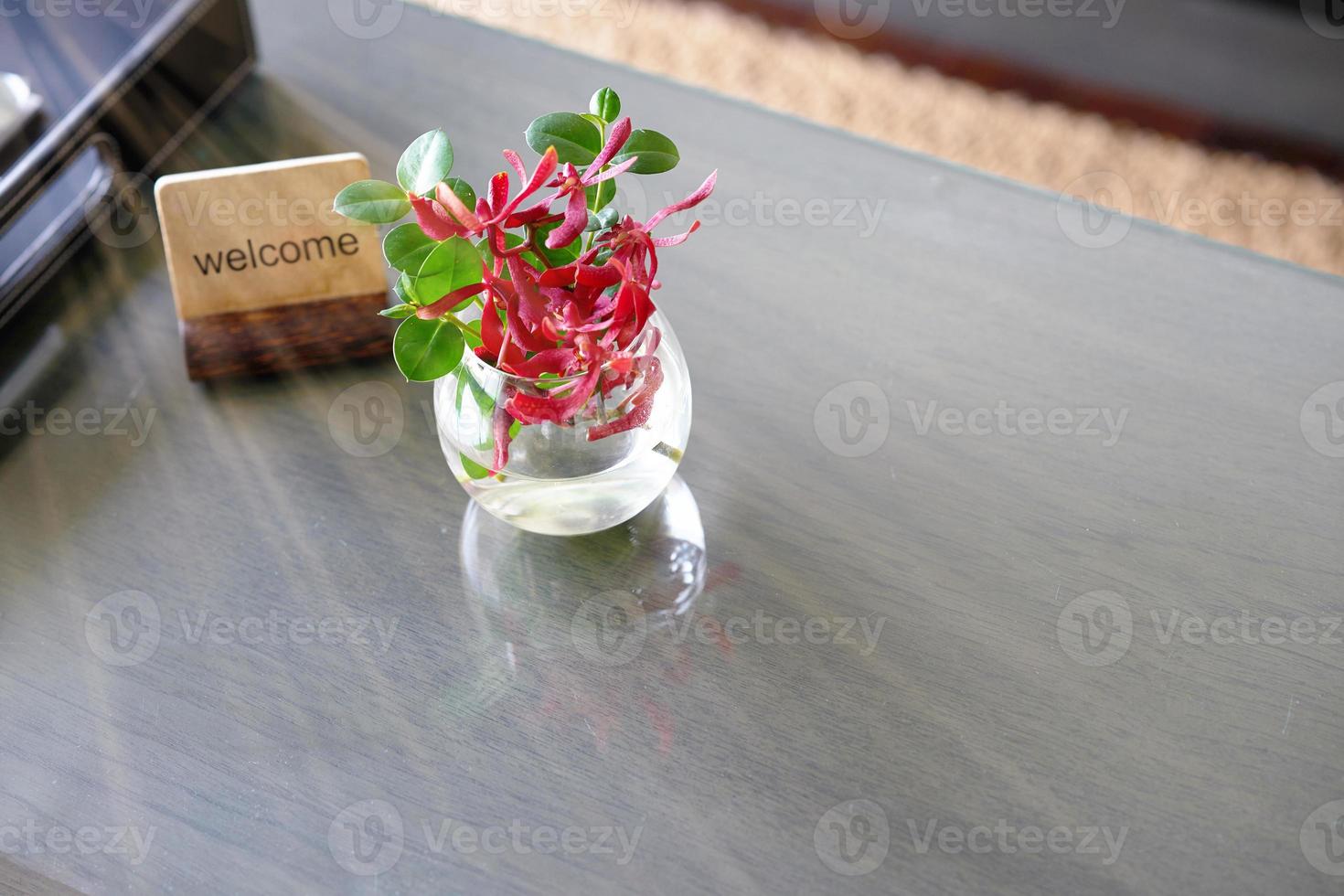 Welcome label stand with flower water vase on table for welcome reception concept photo