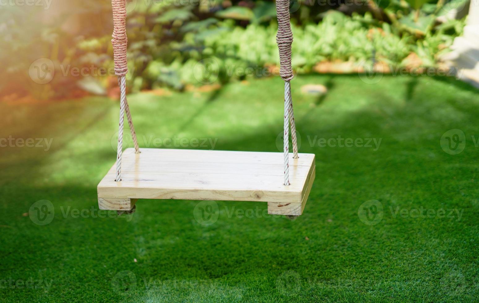 Wooden swings on blur green garden background photo