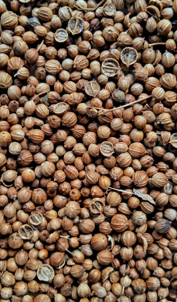 A spreaded dried coriander seed on black background. Ingredient background design. Available for text. Suitable for the food advertising of company and industry, poster, backdrop, flyer, etc. photo