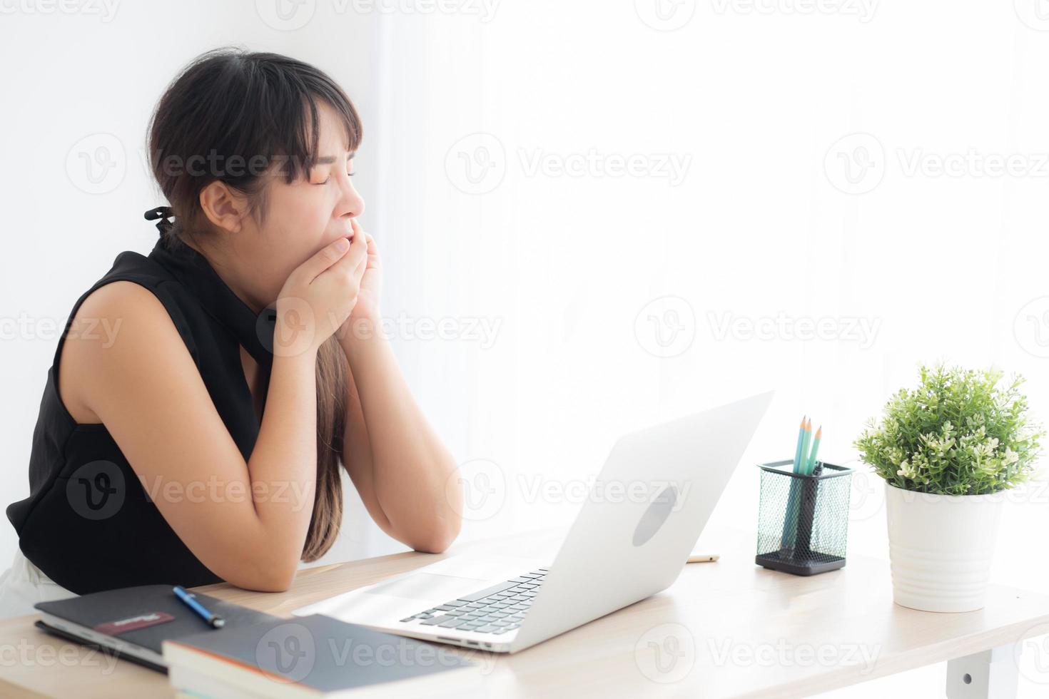 beautiful young freelance asian woman working bored and tired on laptop computer at the office, girl lazy sleepy and yawning on notebook, female secretary with exhausted, business concept. photo