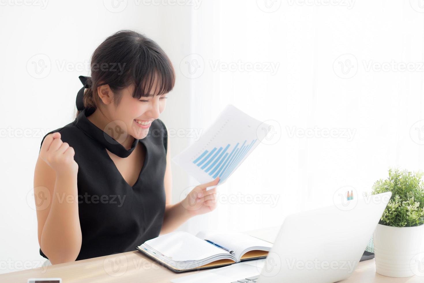 Beautiful young asian woman working laptop computer at office, businesswoman looking graph diagram analysis statistic data with excited and success, girl using notebook, business concept. photo