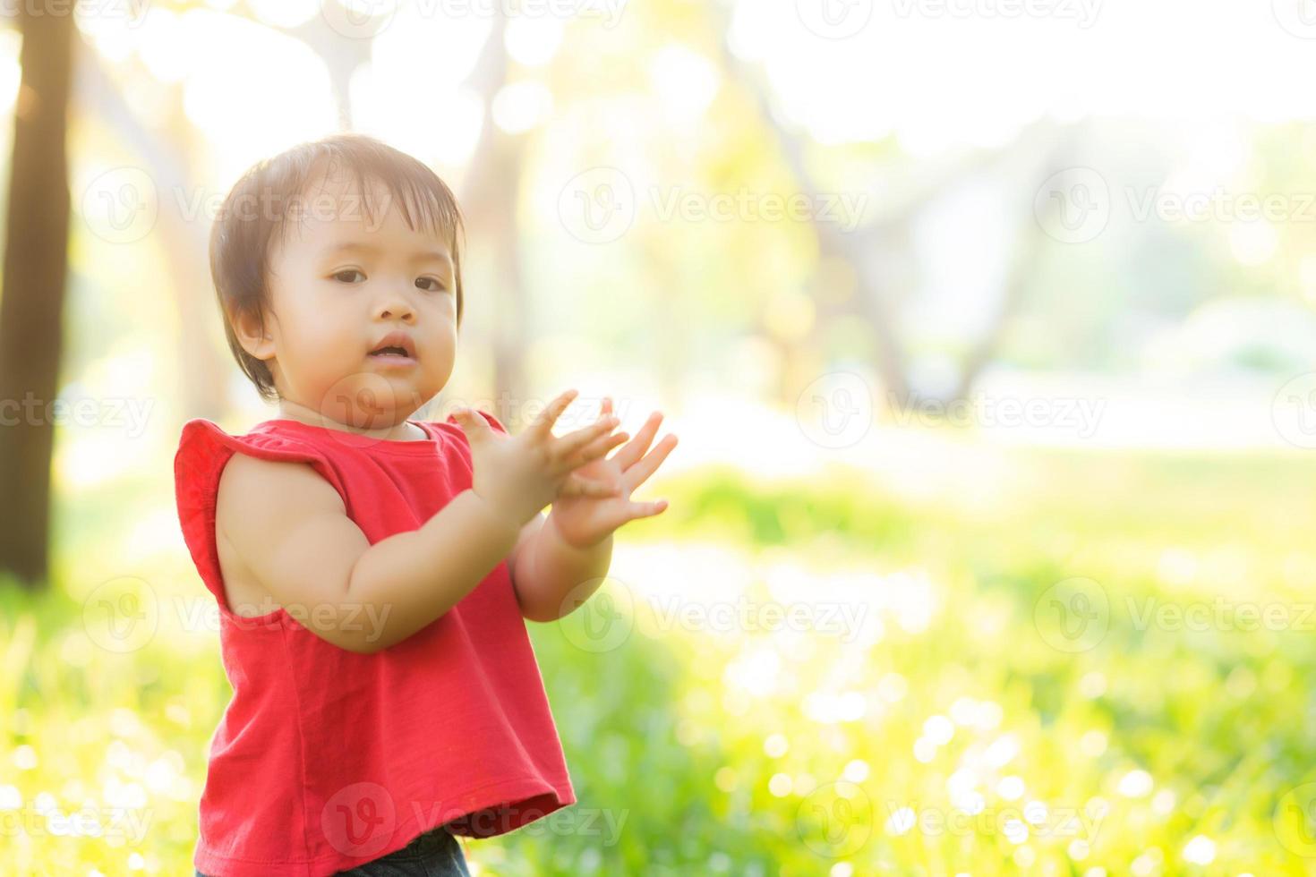 cara de retrato de linda niña asiática y felicidad y diversión infantil en el parque en verano, sonrisa y felicidad de niño asiático y relajación en el jardín, concepto de infancia de estilo de vida. foto