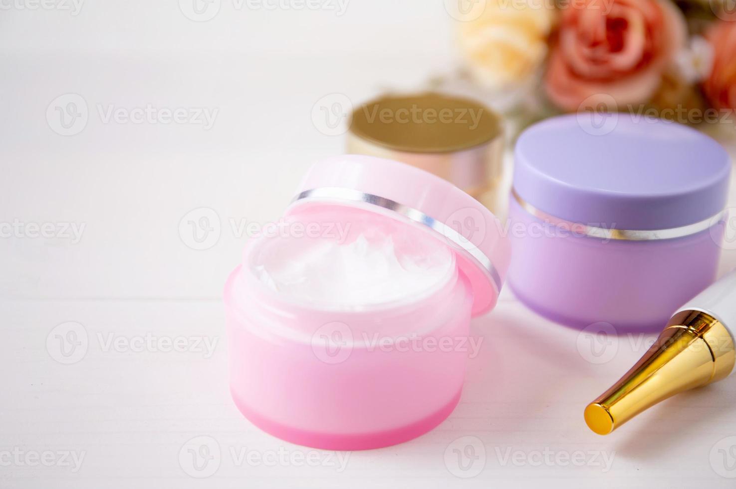 cosmetic and skin care product and flower on white wood table, beauty with treatment cream and moisturizing on wooden desk, health and wellness concept. photo