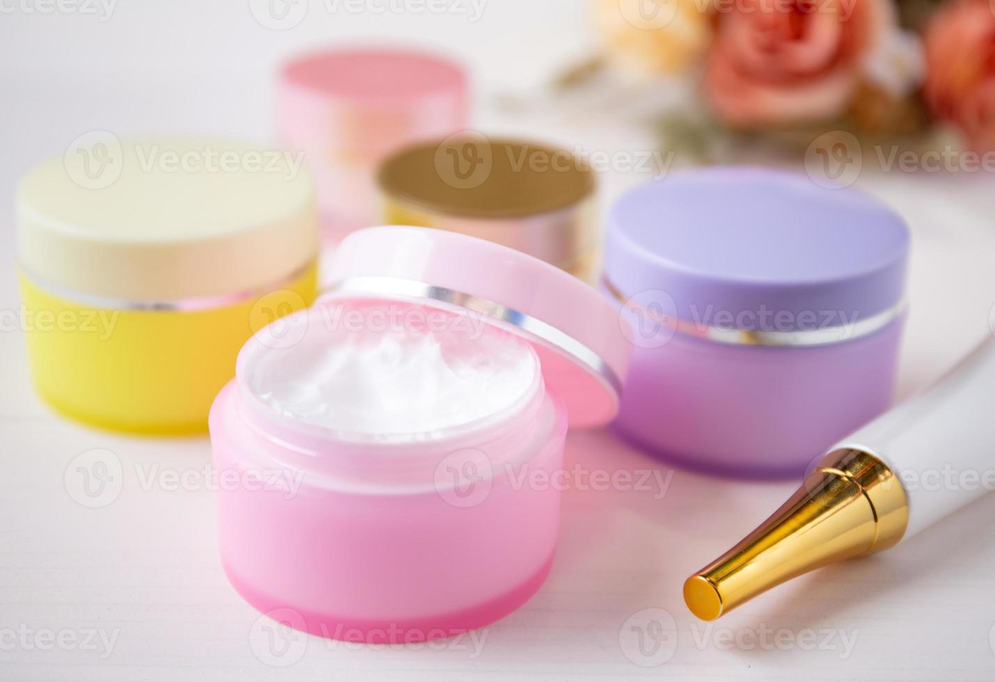 cosmetic and skin care product and flower on white wood table, beauty with treatment cream and moisturizing on wooden desk, health and wellness concept. photo