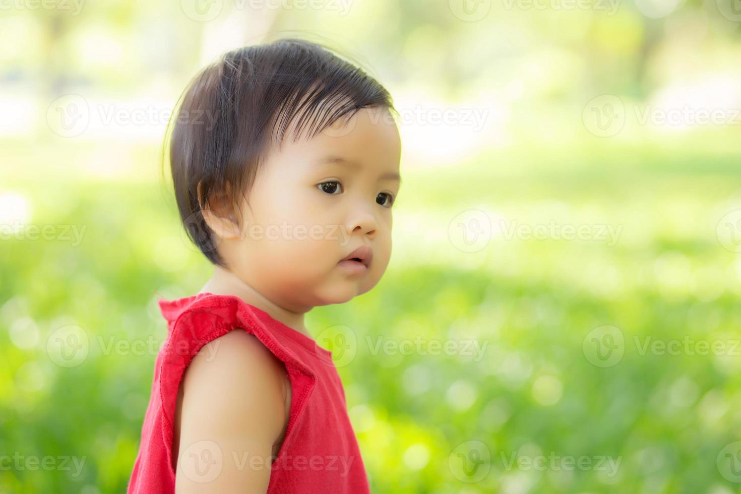 Portrait face of cute asian little girl and child happiness and fun in the park in the summer, smile and happy from asia kid and relax in the garden, lifestyle childhood concept. photo