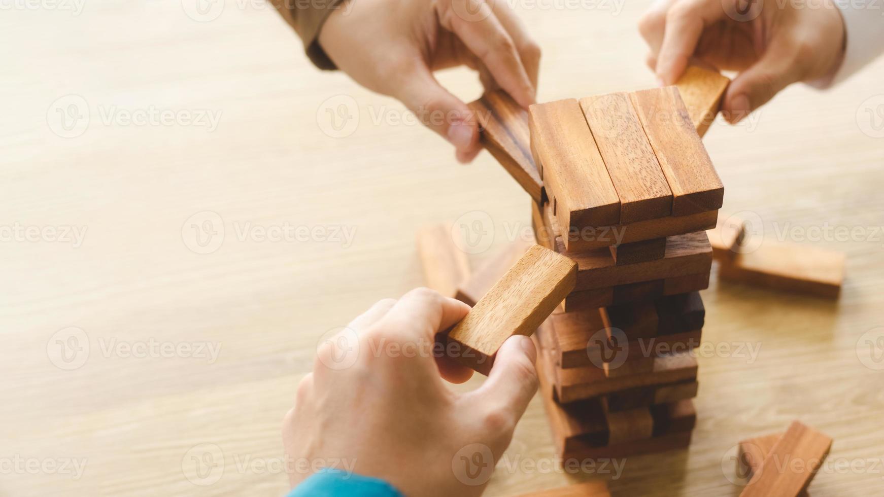 Business management concepts and business strategies, a team of young geniuses playing wooden games, expressing corporate vision, preventing risks from future crises. photo