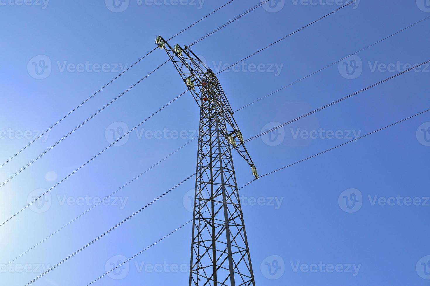 Close up view on a big power pylon transporting electricity in a countryside area photo