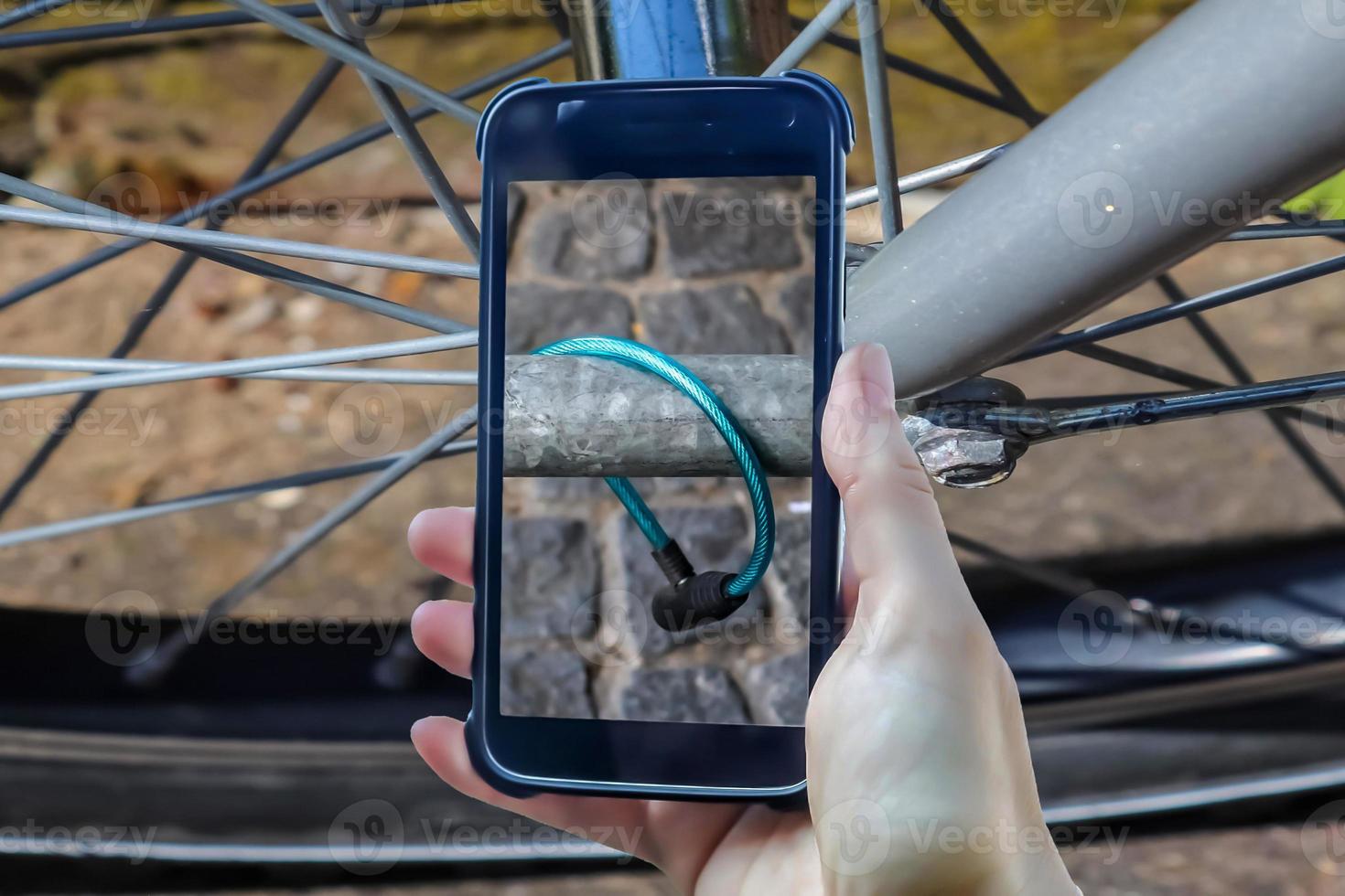 Bicycle robbery composing of a female hand holding a smartphone taking a picture. photo