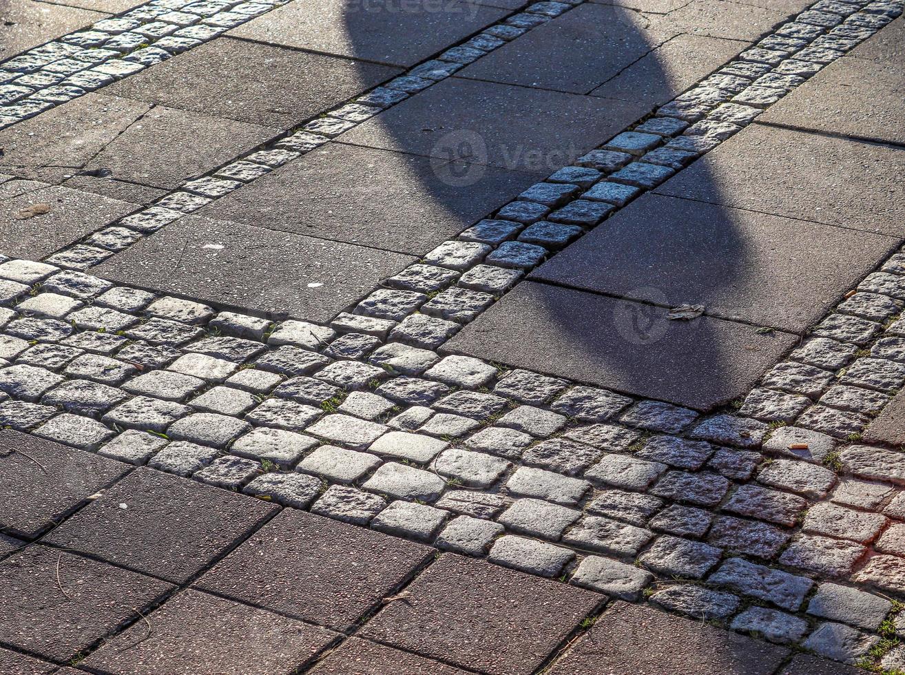 Shadows of people in a european shopping area on a cobblestone ground photo