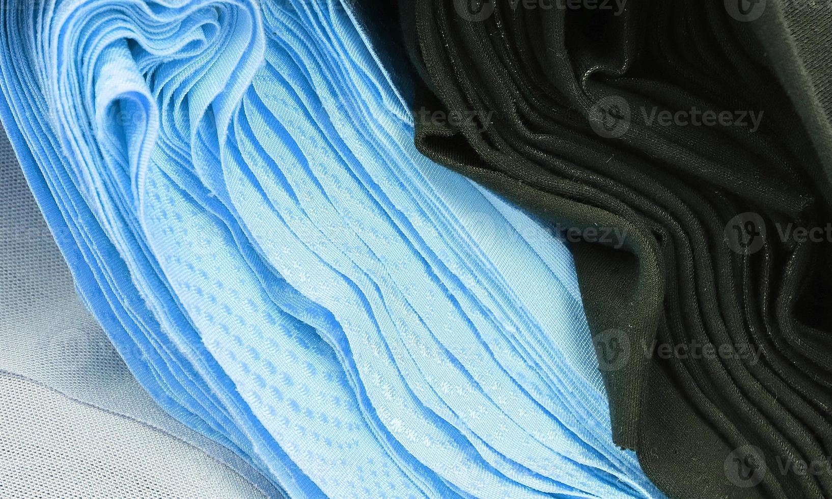 Detailed close up view on samples of cloth and fabrics in different colors found at a fabrics market photo