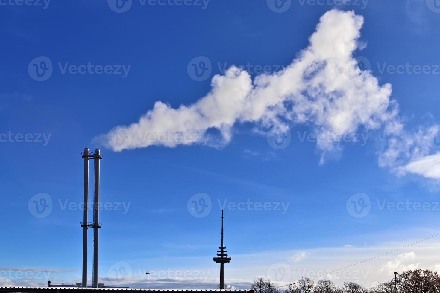 contaminación industrial de las chimeneas de fábrica en un cielo azul profundo foto