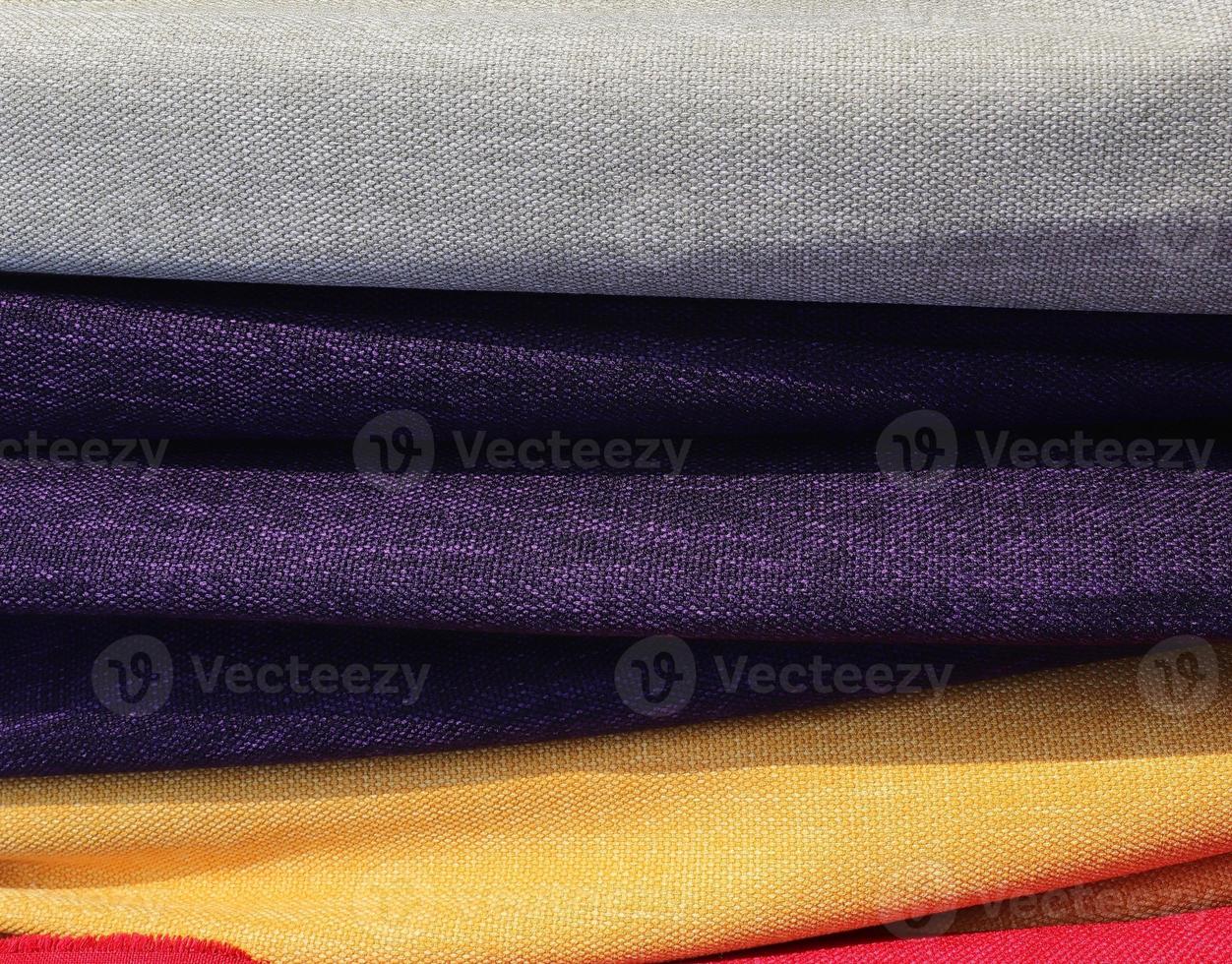 Detailed close up view on samples of cloth and fabrics in different colors found at a fabrics market photo