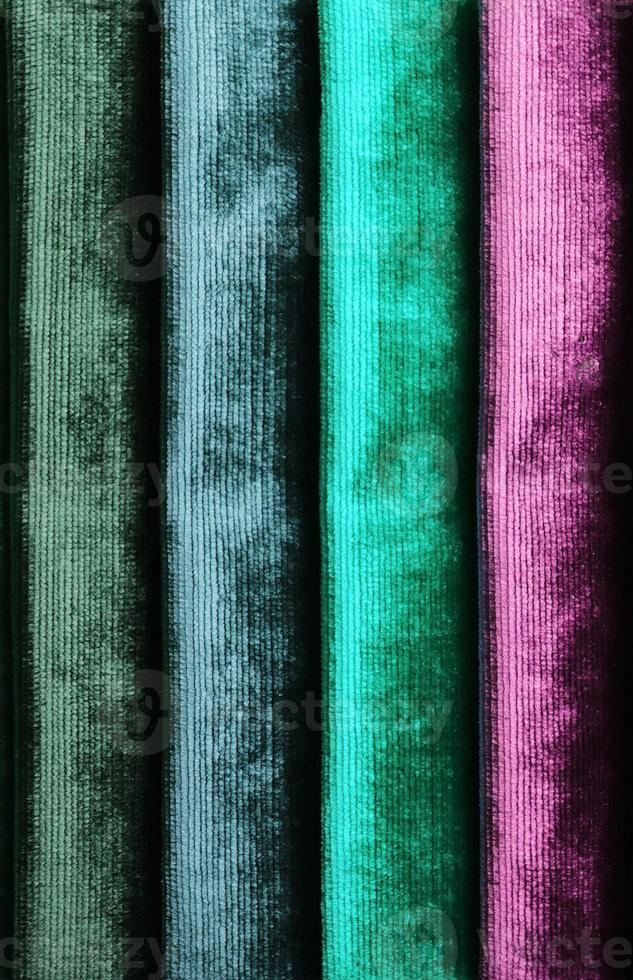 Detailed close up view on samples of cloth and fabrics in different colors found at a fabrics market photo