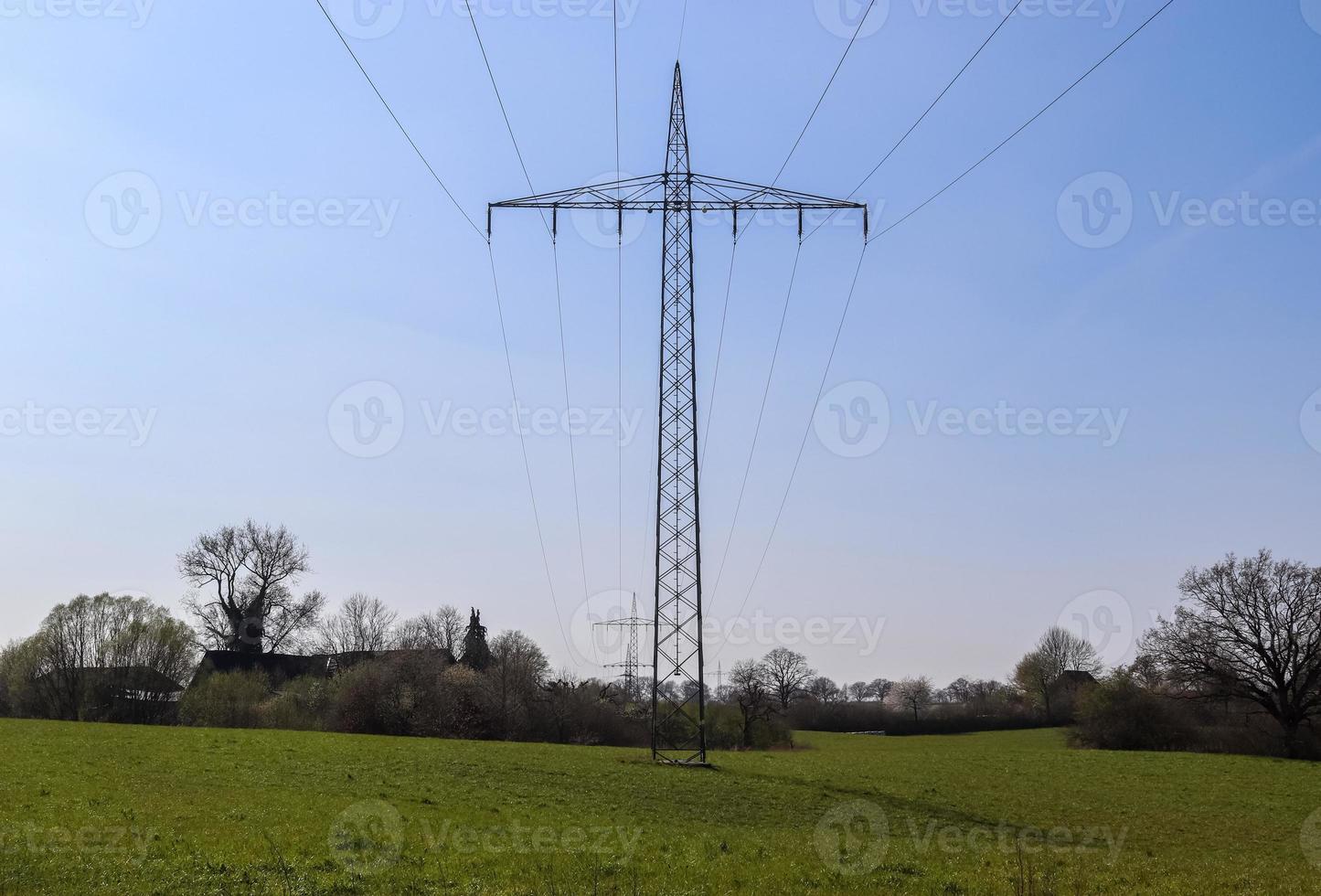 Close up view on a big power pylon transporting electricity in a countryside area photo