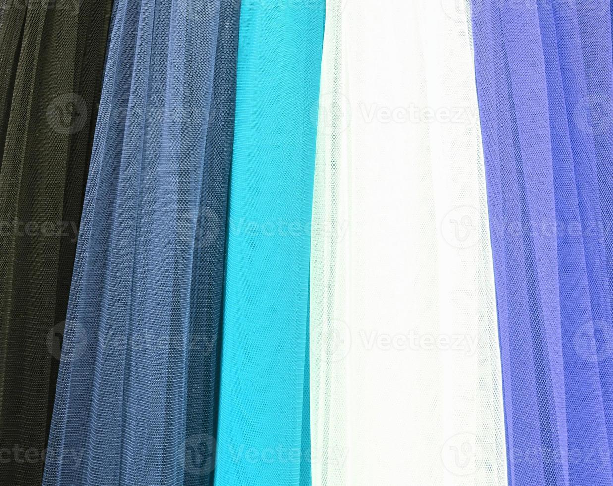 Detailed close up view on samples of cloth and fabrics in different colors found at a fabrics market photo