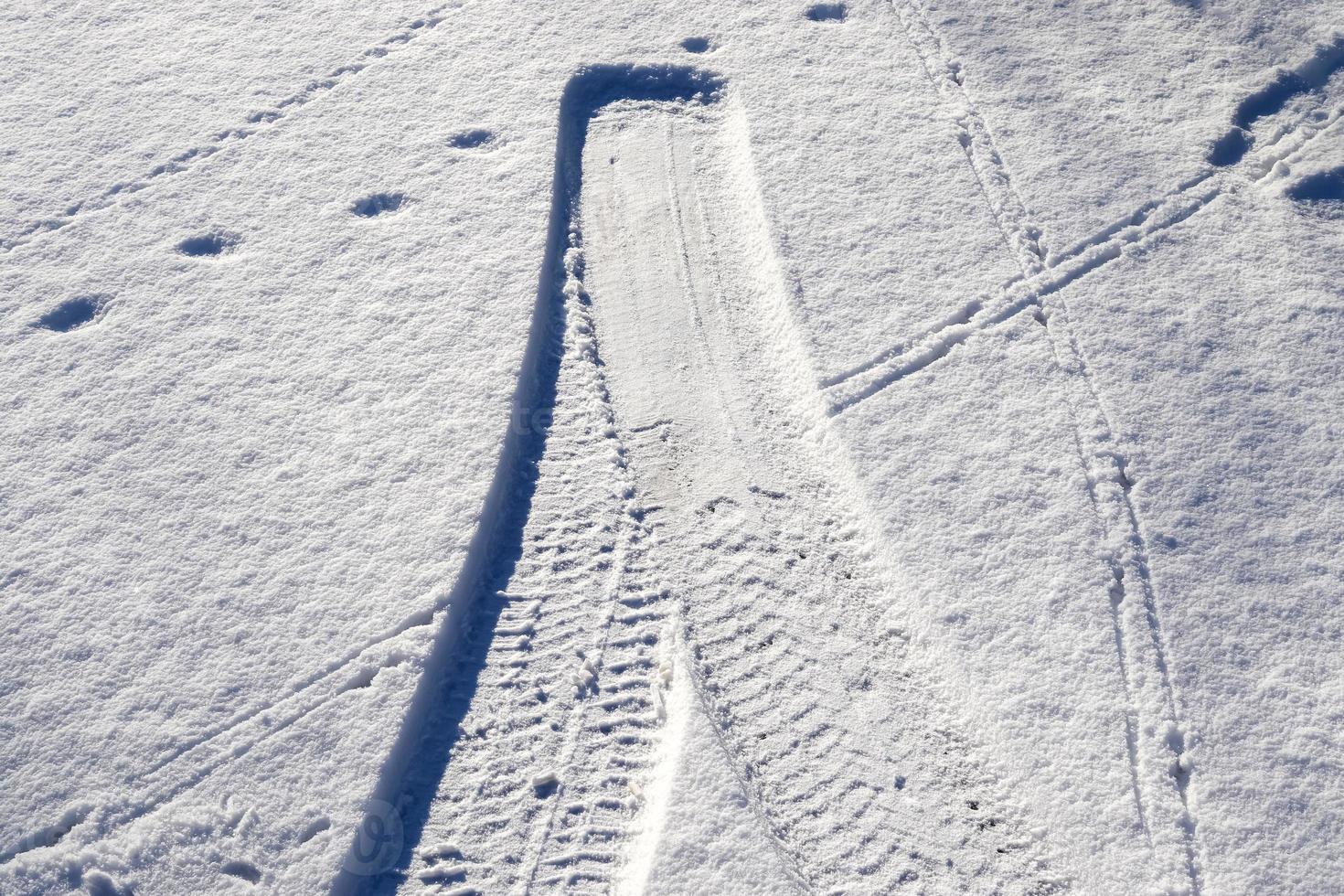 Tire Tracks on snow covered streets in a close up view. photo