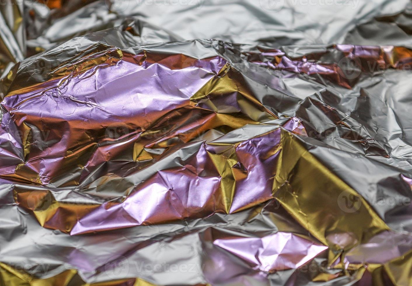Detailed close up texture of an aluminum foil surface in different colors. photo