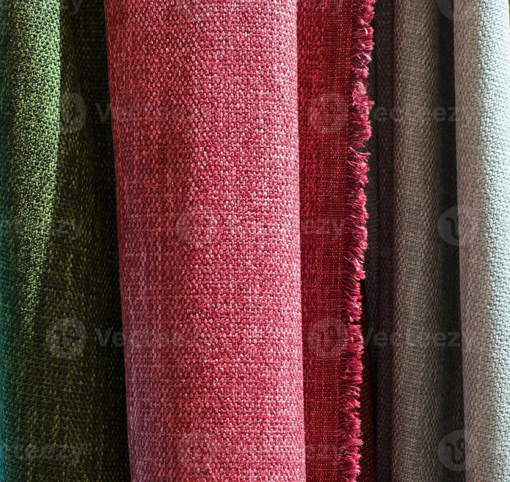 Detailed close up view on samples of cloth and fabrics in different colors found at a fabrics market photo