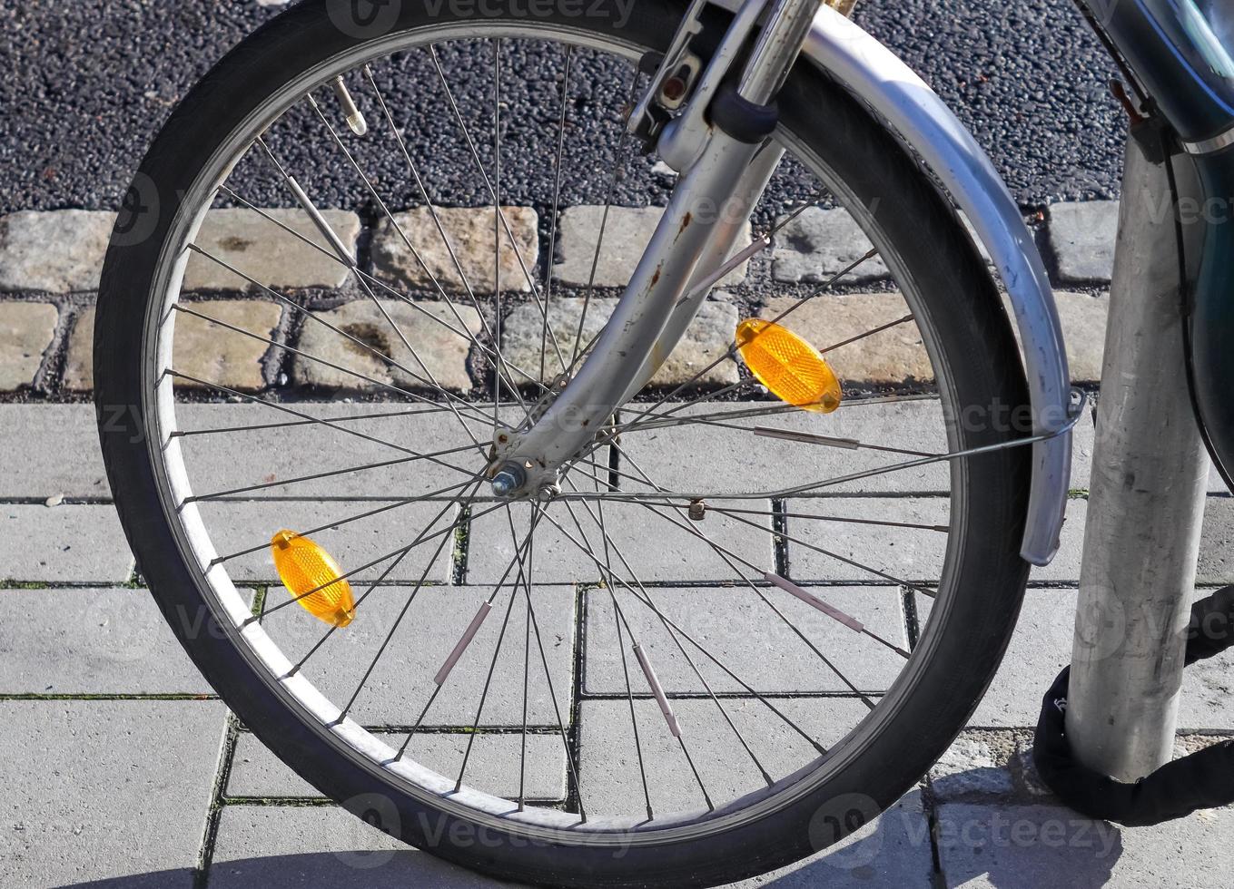 Close up view at a bicycle wheel with several metal spokes photo