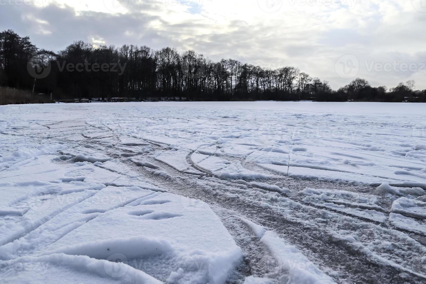ver en un lago congelado durante el invierno con un montón de pistas de patinaje sobre hielo. foto