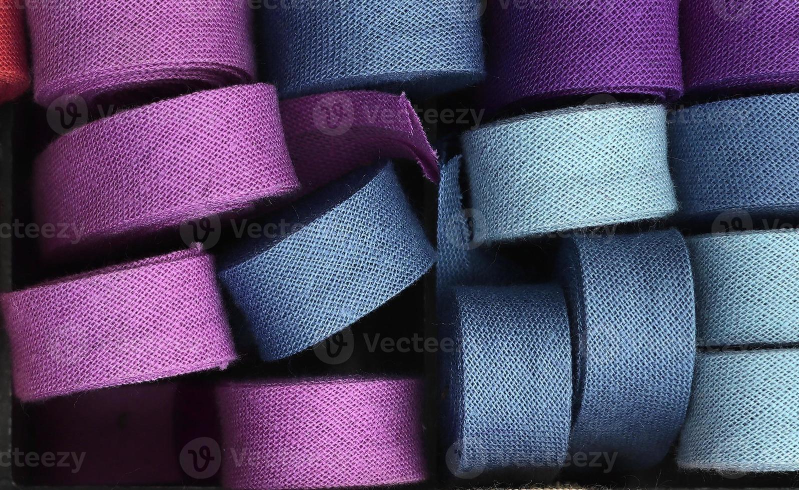 Detailed close up view on samples of cloth and fabrics in different colors found at a fabrics market photo