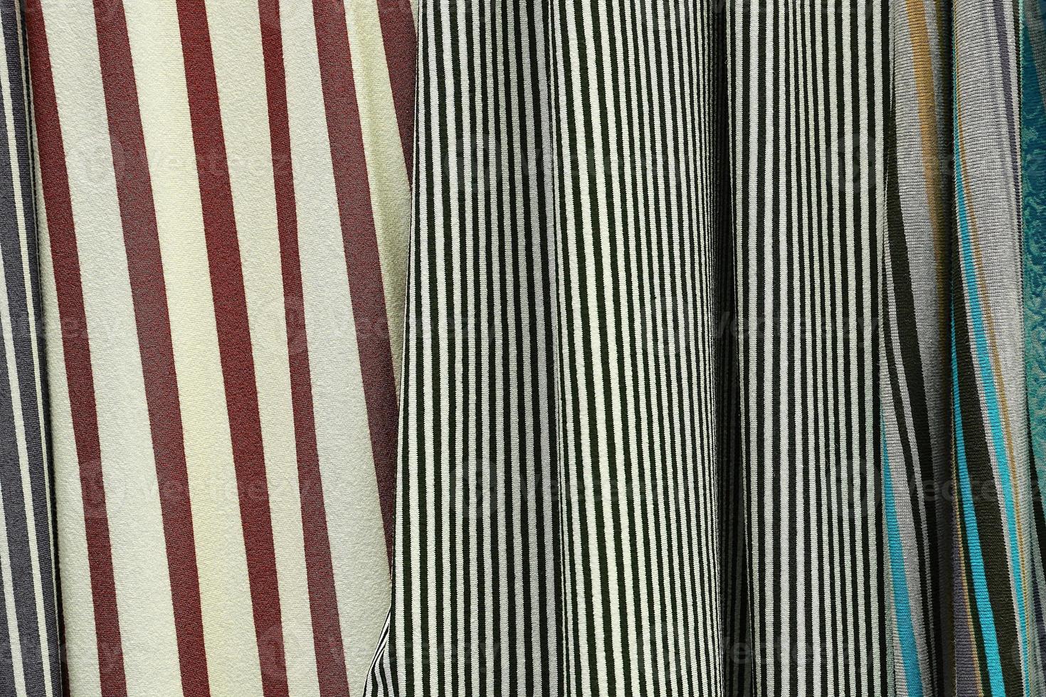 Detailed close up view on samples of cloth and fabrics in different colors found at a fabrics market photo