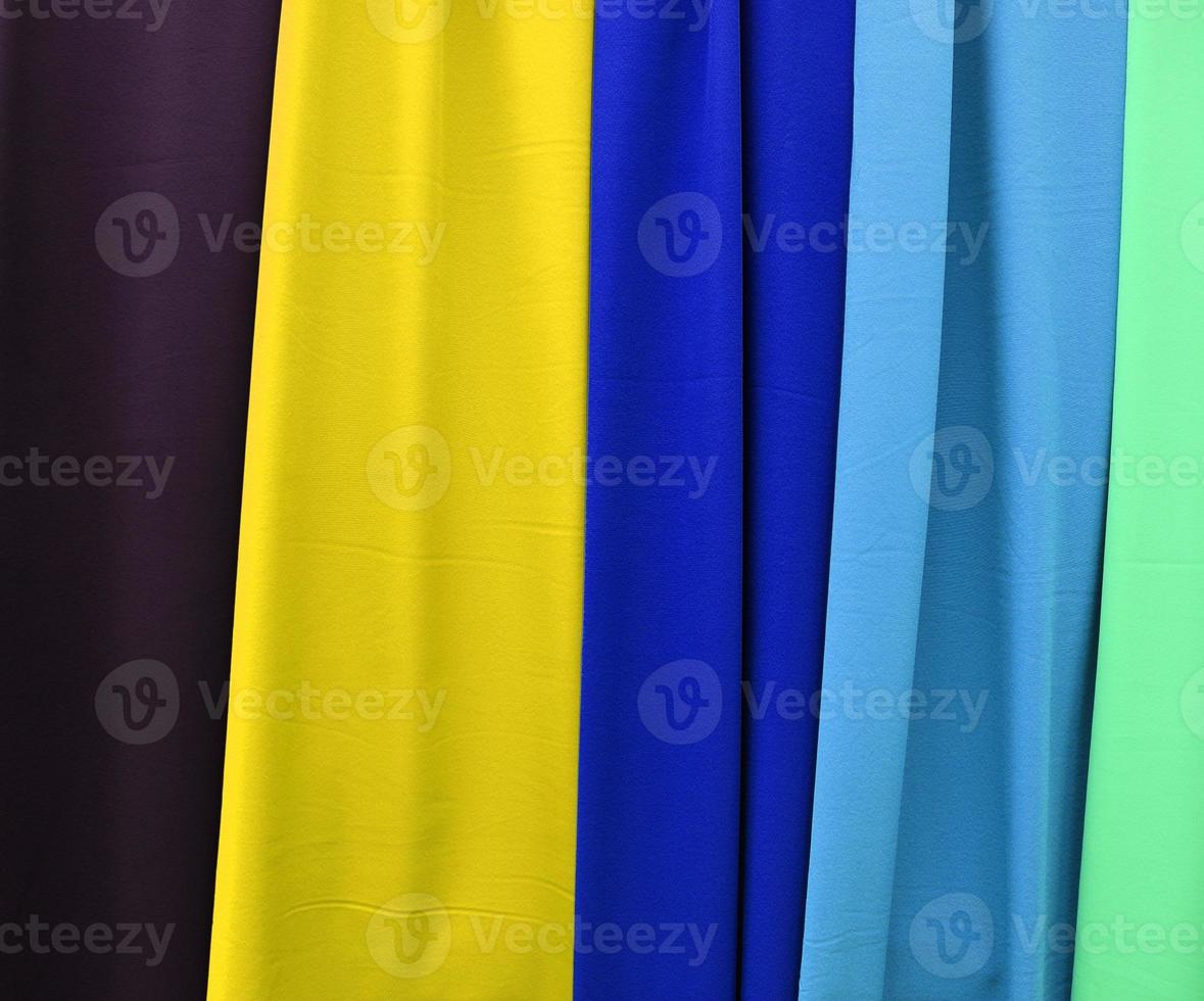 Detailed close up view on samples of cloth and fabrics in different colors found at a fabrics market photo
